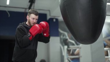 Spor salonunda antrenman yaparken erkek boksör, 8K 'da ağır çekim.
