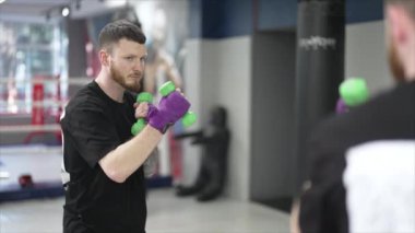 Spor salonunda antrenman yaparken erkek boksör, 8K 'da ağır çekim.