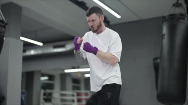 Spor salonunda antrenman yaparken erkek boksör, 8K 'da ağır çekim.