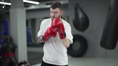 Spor salonunda antrenman yaparken erkek boksör, 8K 'da ağır çekim.