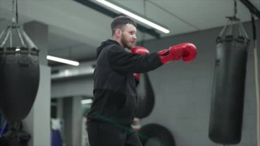 Spor salonunda antrenman yaparken erkek boksör, 8K 'da ağır çekim.