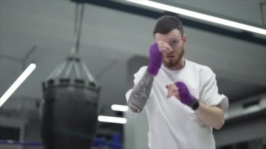 Spor salonunda antrenman yaparken erkek boksör, 8K 'da ağır çekim.