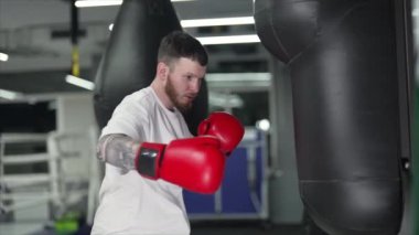 Spor salonunda antrenman yaparken erkek boksör, 8K 'da ağır çekim.