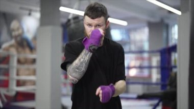 Spor salonunda antrenman yaparken erkek boksör, 8K 'da ağır çekim.