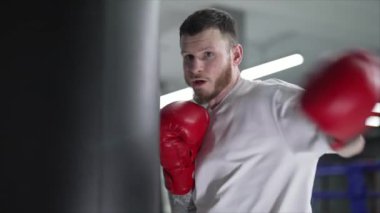 Spor salonunda antrenman yaparken erkek boksör, 8K 'da ağır çekim.