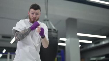 Spor salonunda antrenman yaparken erkek boksör, 8K 'da ağır çekim.