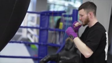 Spor salonunda antrenman yaparken erkek boksör, 8K 'da ağır çekim.
