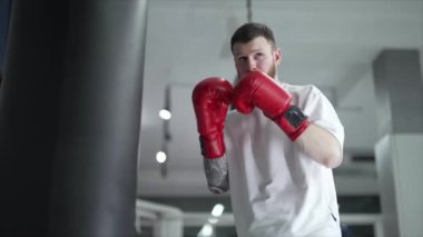 Spor salonunda antrenman yaparken erkek boksör, 8K 'da ağır çekim.