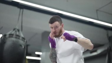 Spor salonunda antrenman yaparken erkek boksör, 8K 'da ağır çekim.