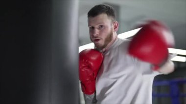 Spor salonunda antrenman yaparken erkek boksör, 8K 'da ağır çekim.