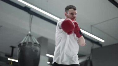 Spor salonunda antrenman yaparken erkek boksör, 8K 'da ağır çekim.