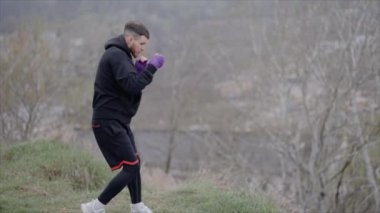 Erkek boksör şehir dışında spor antrenmanında, yavaş çekim ise 8K 'da.