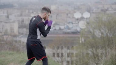 Erkek boksör şehir dışında spor antrenmanında, yavaş çekim ise 8K 'da.