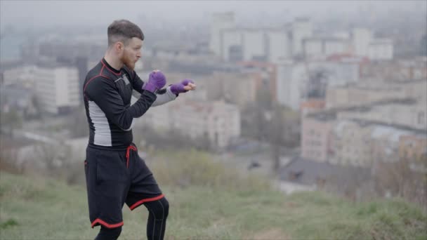 男のボクサーは 市内の屋外スポーツトレーニング 8Kでスローモーションに従事しています — ストック動画