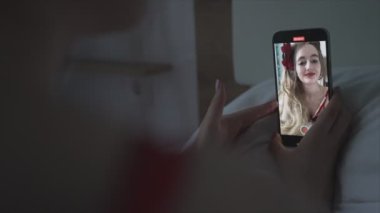 Genç kız akıllı telefondan selfie çekiyor.