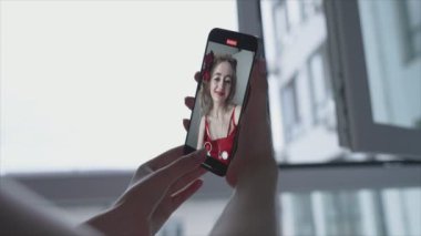 Genç kız akıllı telefondan selfie çekiyor.