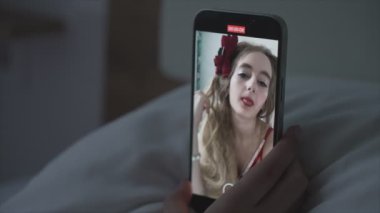 Genç kız akıllı telefondan selfie çekiyor.