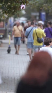 KYIV, UKRAINE 1 Eylül 2024: Bir şehir caddesindeki kalabalığın dikey videosu