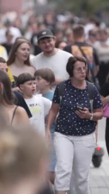 KYIV, UKRAINE 1 Eylül 2024: Bir şehir caddesindeki kalabalığın dikey videosu