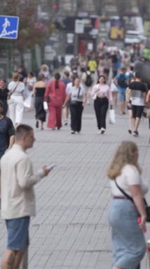KYIV, UKRAINE SEPTEMBER 1, 2024: Bir şehir caddesinde yavaş çekim bir kalabalığın dikey videosu.