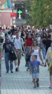 KYIV, UKRAINE SEPTEMBER 1, 2024: Bir şehir caddesinde yavaş çekim bir kalabalığın dikey videosu.