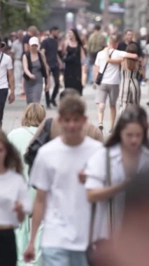 KYIV, UKRAINE SEPTEMBER 1, 2024: Bir şehir caddesinde yavaş çekim bir kalabalığın dikey videosu.