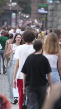 KYIV, UKRAINE SEPTEMBER 1, 2024: Bir şehir caddesinde yavaş çekim bir kalabalığın dikey videosu.