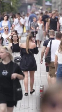 KYIV, UKRAINE SEPTEMBER 1, 2024: Bir şehir caddesinde yavaş çekim bir kalabalığın dikey videosu.