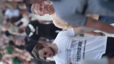 KYIV, UKRAINE - 30 AĞUSTOS 2024: Yazın bir şehir caddesinde kalabalığın dikey videosu.