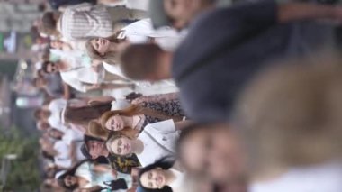 KYIV, UKRAINE - 30 AĞUSTOS 2024: Yazın bir şehir caddesinde kalabalığın dikey videosu.