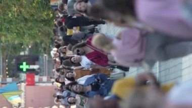 KYIV, UKRAINE - 30 AĞUSTOS 2024: Yazın bir şehir caddesinde kalabalığın dikey videosu.