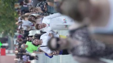 KYIV, UKRAINE - 30 Ağustos 2024: Yazın yürüyen kalabalığın dikey videosu