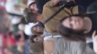 KYIV, UKRAINE - 30 Ağustos 2024: Yazın yürüyen kalabalığın dikey videosu