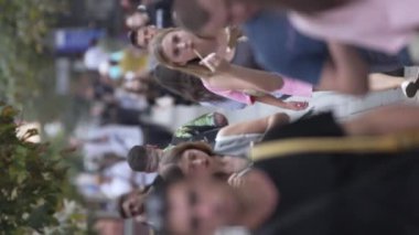 KYIV, UKRAINE - 30 Ağustos 2024: Yazın yürüyen kalabalığın dikey videosu