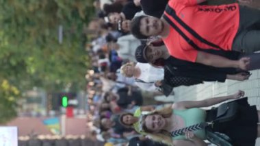 KYIV, UKRAINE - 30 Ağustos 2024: Yazın yürüyen kalabalığın dikey videosu