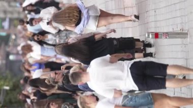 KYIV, UKRAINE - 30 AĞUSTOS 2024: Khreshchatyk 'in merkez caddesindeki insanların yaz aylarında ağır çekimde çekilmiş dikey videosu.