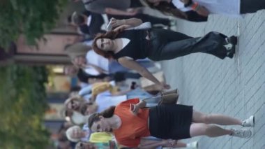 KYIV, UKRAINE - 30 AĞUSTOS 2024: Khreshchatyk 'in merkez caddesindeki insanların yaz aylarında ağır çekimde çekilmiş dikey videosu.