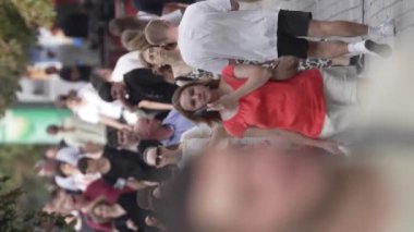 KYIV, UKRAINE - 30 AĞUSTOS 2024: Khreshchatyk 'in merkez caddesindeki insanların yaz aylarında ağır çekimde çekilmiş dikey videosu.