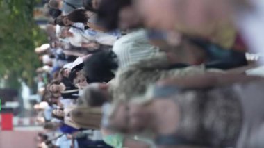 KYIV, UKRAINE - 30 AĞUSTOS 2024: Khreshchatyk 'in merkez caddesindeki insanların yaz aylarında ağır çekimde çekilmiş dikey videosu.