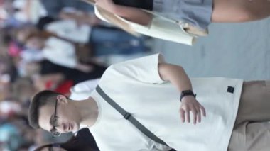 KYIV, UKRAINE - 30 AĞUSTOS 2024: Khreshchatyk 'in merkez caddesindeki insanların yaz aylarında ağır çekimde çekilmiş dikey videosu.