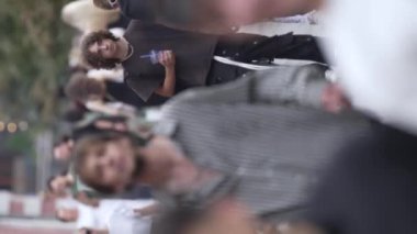 KYIV, UKRAINE - 30 AĞUSTOS 2024: Yazın bir şehir caddesinde kalabalığın dikey videosu.