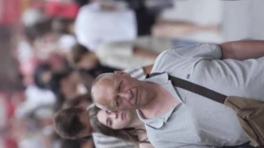 KYIV, UKRAINE - 30 AĞUSTOS 2024: Yazın bir şehir caddesinde kalabalığın dikey videosu.