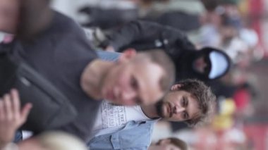 KYIV, UKRAINE - 30 AĞUSTOS 2024: Yazın bir şehir caddesinde kalabalığın dikey videosu.