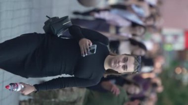 KYIV, UKRAINE - 30 AĞUSTOS 2024: Yazın bir şehir caddesinde kalabalığın dikey videosu.