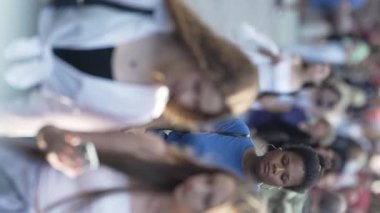 KYIV, UKRAINE - 30 AĞUSTOS 2024: Yazın bir şehir caddesinde kalabalığın dikey videosu.