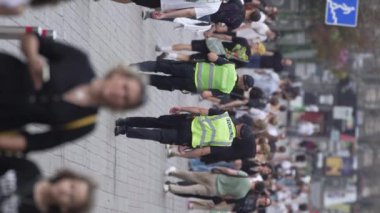 KYIV, UKRAINE - 30 AĞUSTOS 2024: Yazın bir şehir caddesinde kalabalığın dikey videosu.