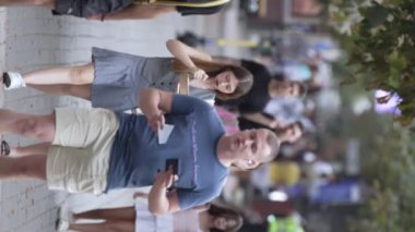 KYIV, UKRAINE - 30 Ağustos 2024: Yazın yürüyen kalabalığın dikey videosu