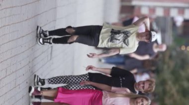 KYIV, UKRAINE 30 AĞUSTOS 2024: Yazın bir şehir caddesinde kalabalığın dikey videosu.