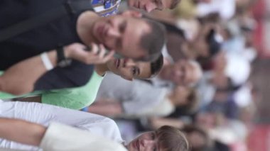 KYIV, UKRAINE 30 AĞUSTOS 2024: Yazın bir şehir caddesinde kalabalığın dikey videosu.