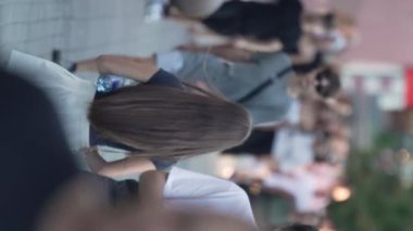 KYIV, UKRAINE 30 AĞUSTOS 2024: Yazın bir şehir caddesinde kalabalığın dikey videosu.